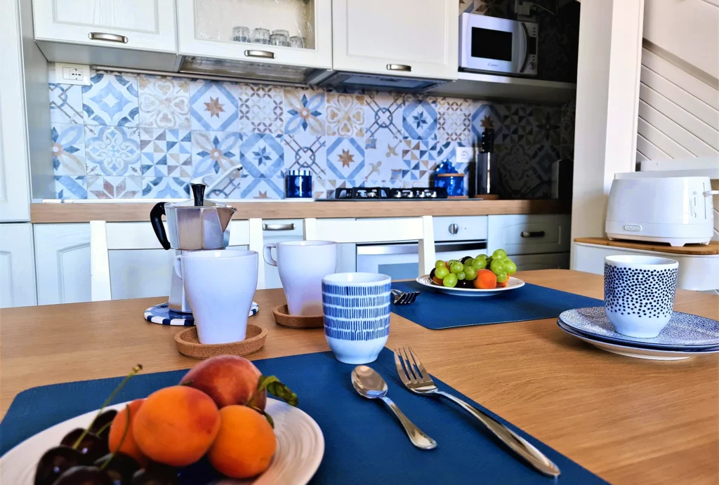 La tavola della colazione con moka, tazze e frutta nella cucina di Suite Carducci Viareggio