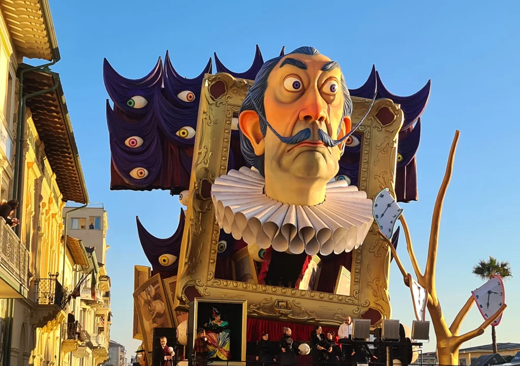 Le char au grand visage à la moustache retroussée défile devant les immeubles du front de mer de Viareggio