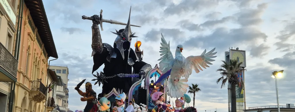Un char du Carnaval de Viareggio avec un chevalier noir à l'épée levée et une colombe blanche, entre les immeubles du front de mer
