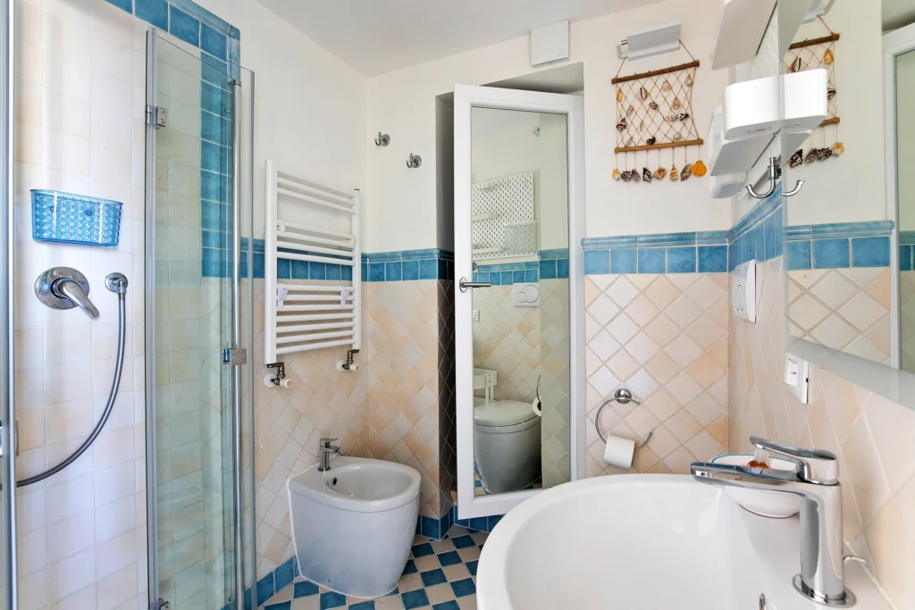 El baño de la Habitación Azul, con la ducha, el lavabo y los azulejos celestes
