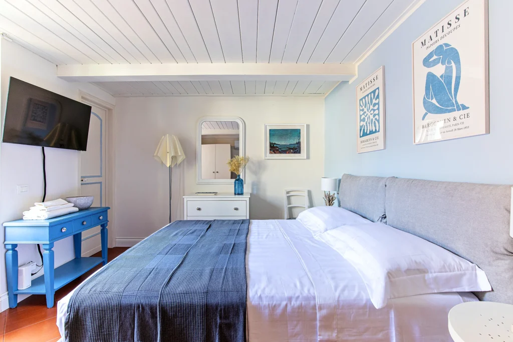 La Habitación Azul vista desde la entrada: la cama, la consola celeste y la Smart TV