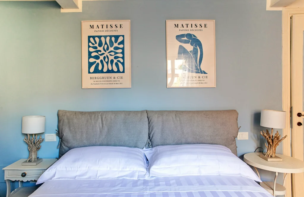 La cama de matrimonio de la Habitación Azul, con dos láminas de Matisse en la pared celeste