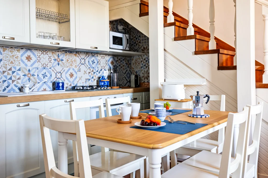 La mesa puesta para el desayuno ante la cocina de azulejos celestes
