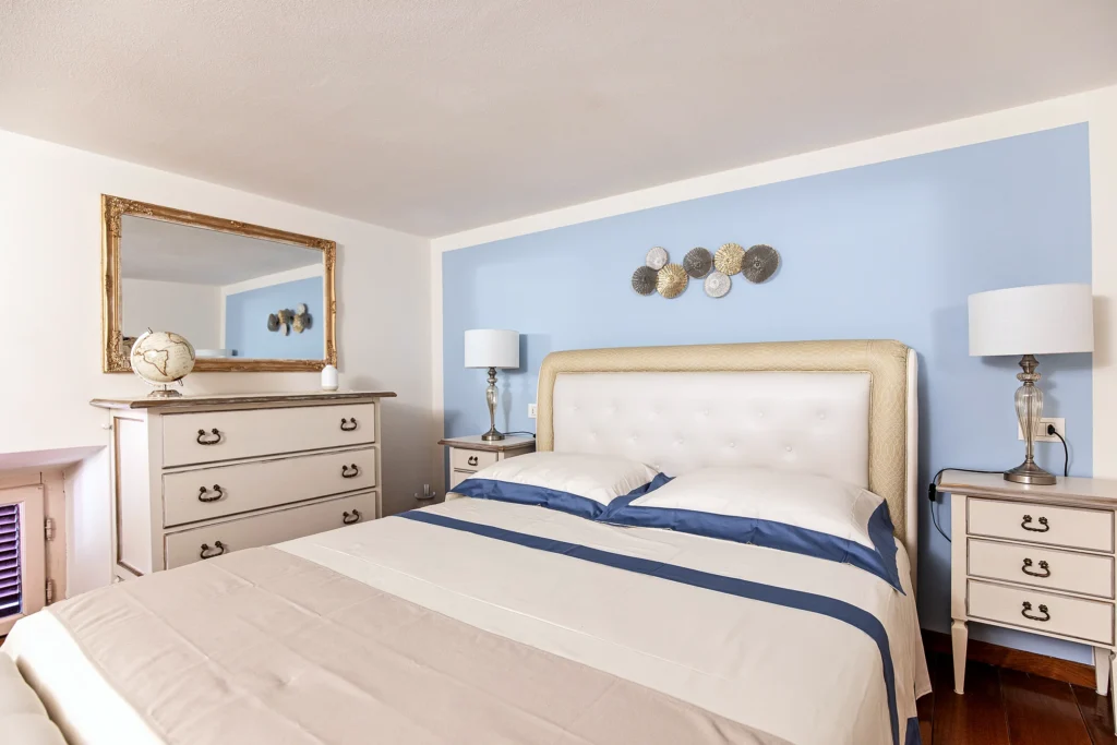 La cama de matrimonio de la Habitación Dorada, con la cómoda y el espejo dorado