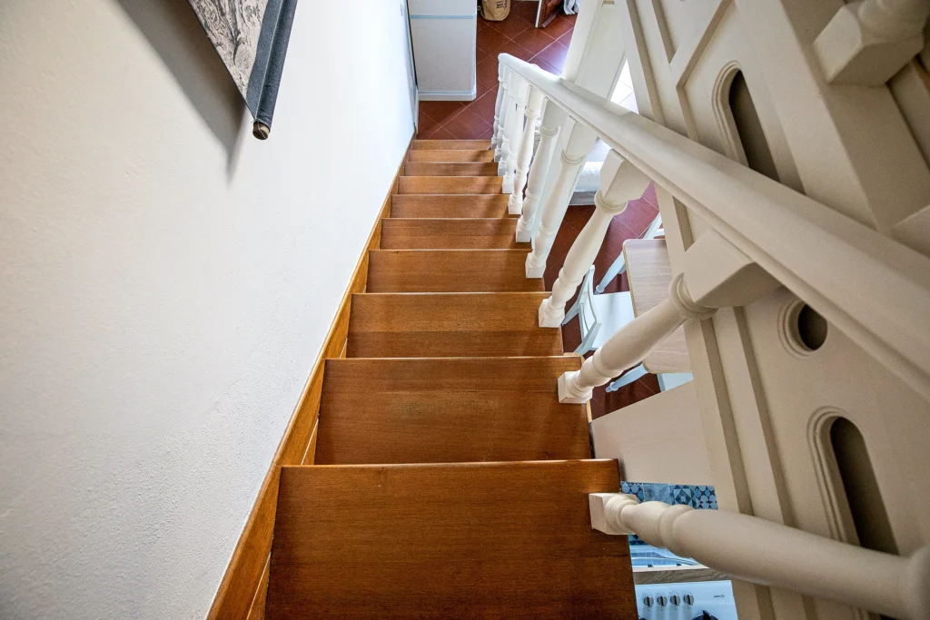 La escalera de madera que sube del salón al altillo