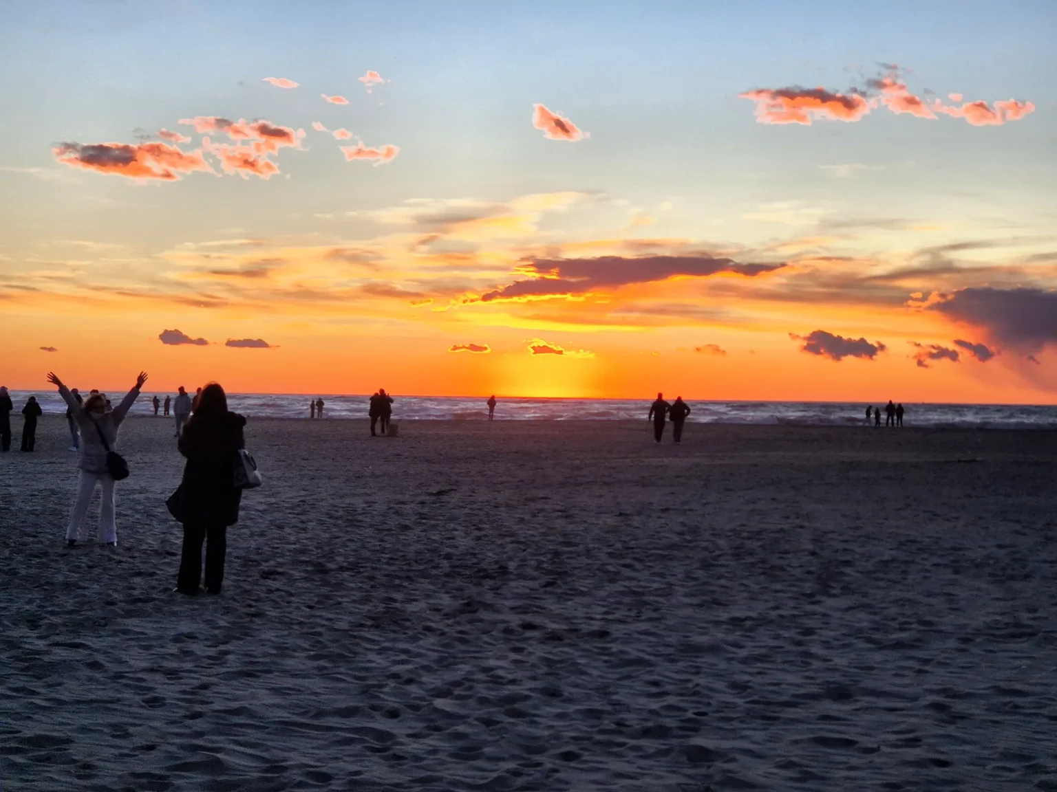 Il tramonto sulla spiaggia di Viareggio il 10 gennaio, con poche persone in controluce