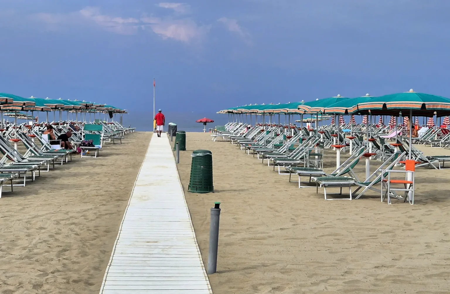La passerella di legno tra gli ombrelloni verso il mare, sulla spiaggia di Viareggio davanti a Suite Carducci Viareggio, in una mattina d'agosto