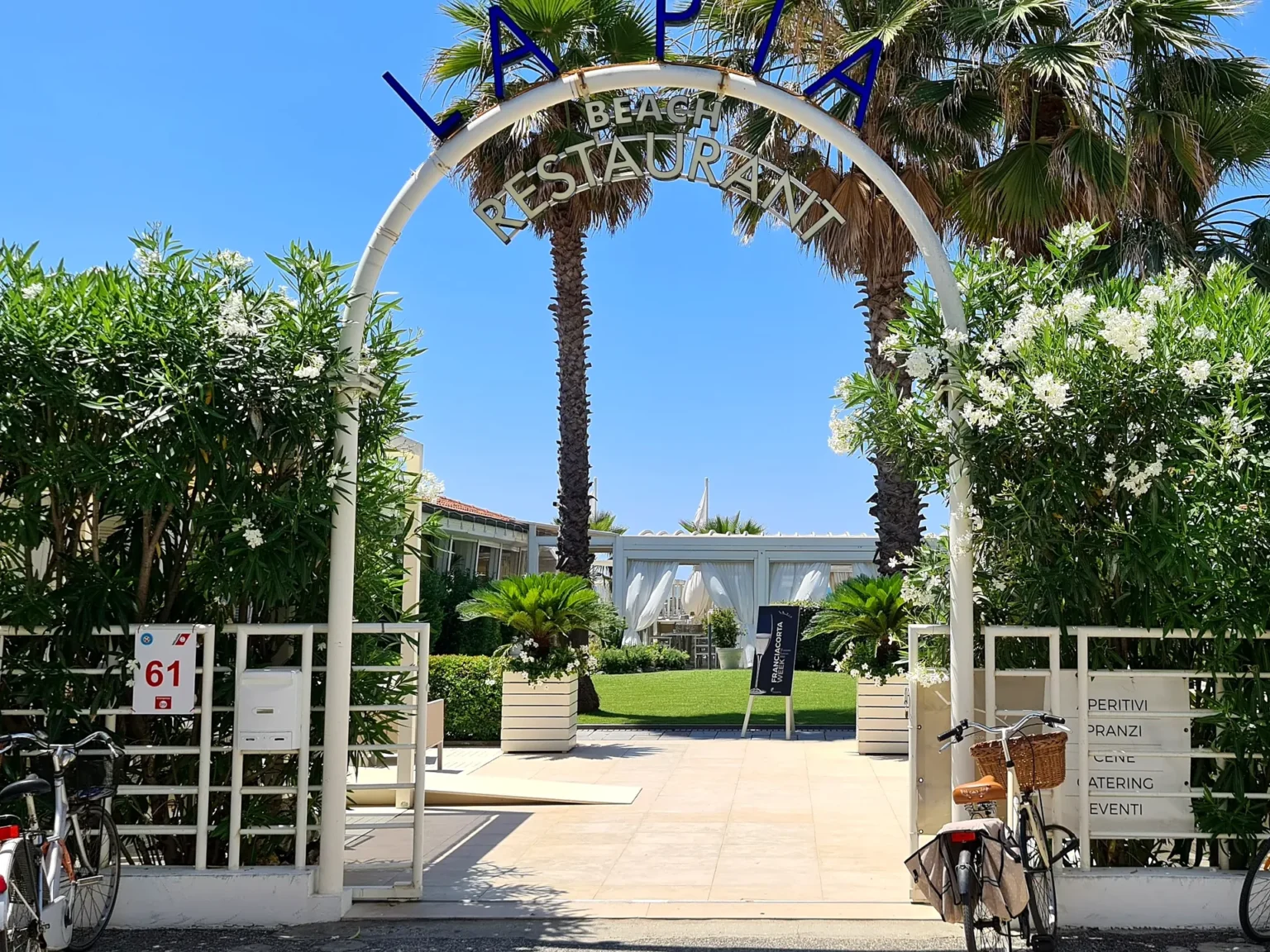 Il giardino della Pia, il ristorante sulla spiaggia, con l'arco tra gli oleandri e le palme