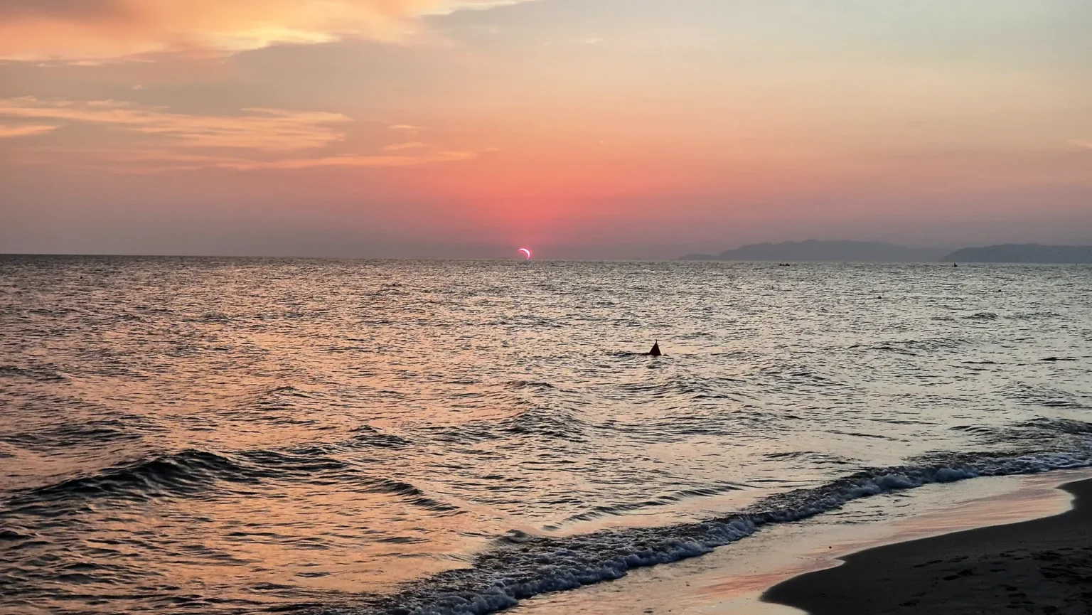Il sole che tramonta sul mare davanti alla spiaggia di Viareggio, ad agosto