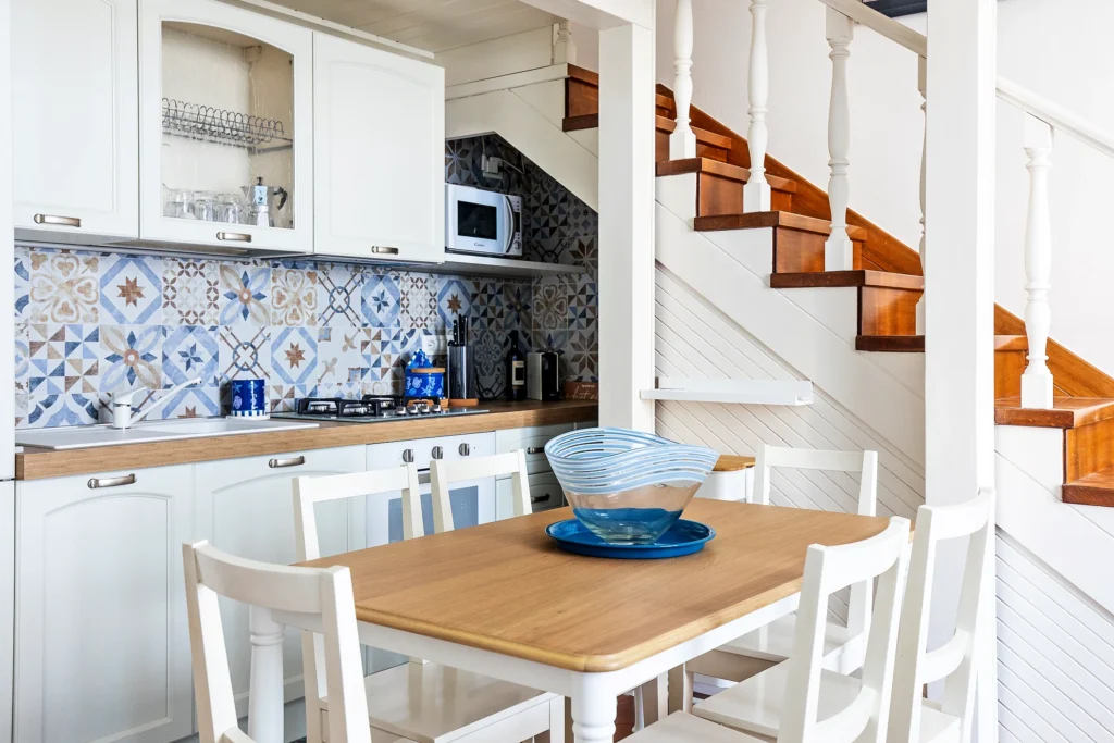 La cucina e il tavolo da pranzo di Suite Carducci Viareggio, con la scala che porta al soppalco